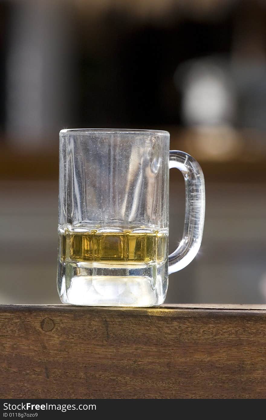 An almost empty mug of beer on a bar the morning after. An almost empty mug of beer on a bar the morning after