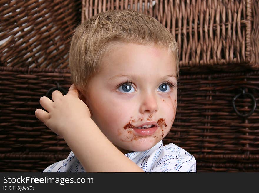 Beautiful blond boy with blue eyes and a dirty mouth, pointing at his ear