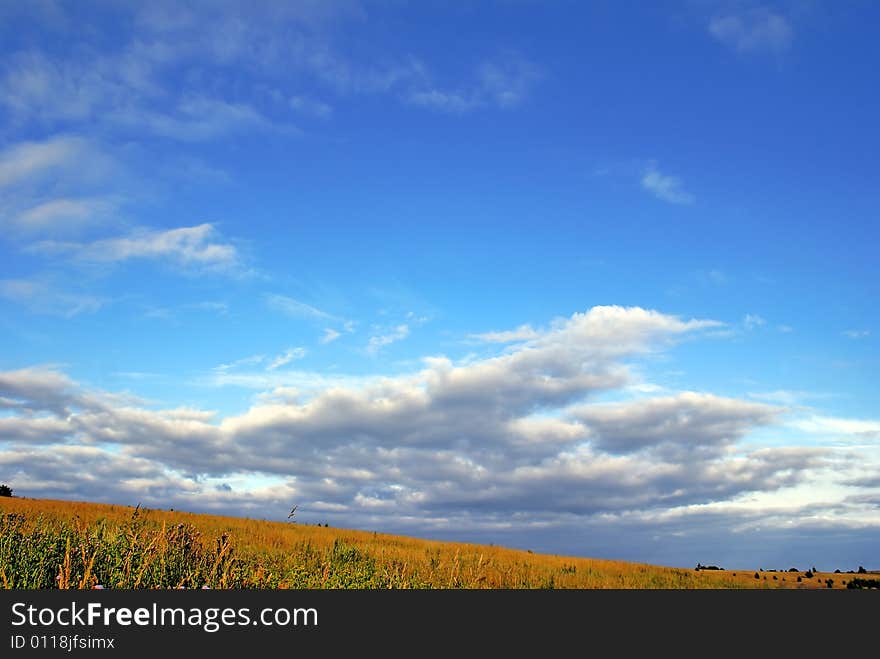 Landscape. Bright, high, blue sky, low dark clouds. Landscape. Bright, high, blue sky, low dark clouds.