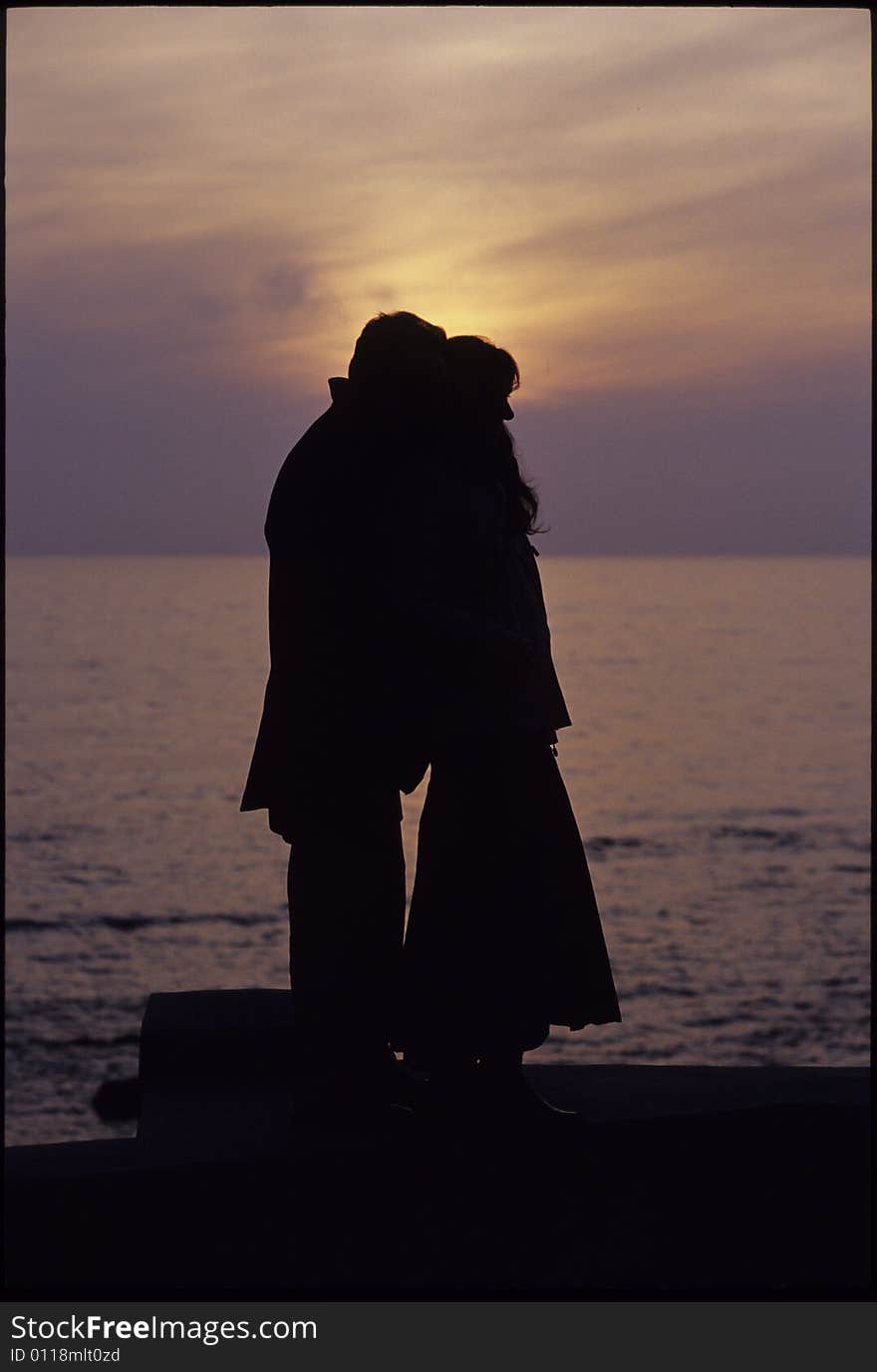 A man and a woman stay together in front of the sea sunset. A man and a woman stay together in front of the sea sunset