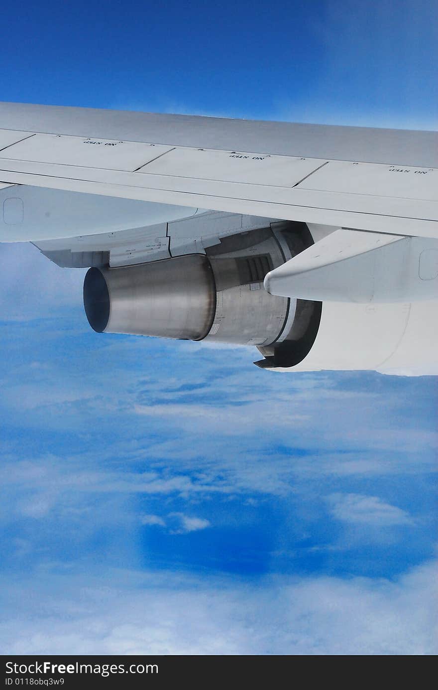 Part of plane wing on the blue sky with white clouds. Part of plane wing on the blue sky with white clouds