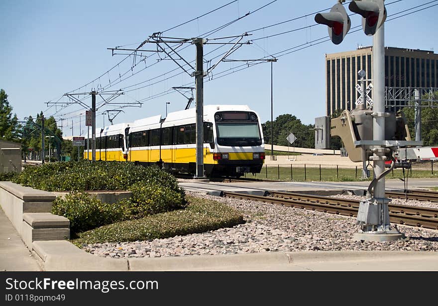 A city rapid transit system traveling down the rail towards the station. A city rapid transit system traveling down the rail towards the station.