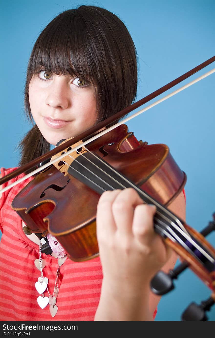 A smiling girl with big hazel eyes playing her viola. A smiling girl with big hazel eyes playing her viola.