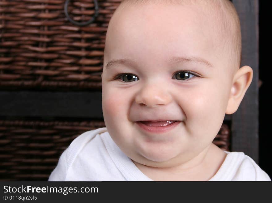 Six month old baby sitting in front of wooden drawers. Six month old baby sitting in front of wooden drawers