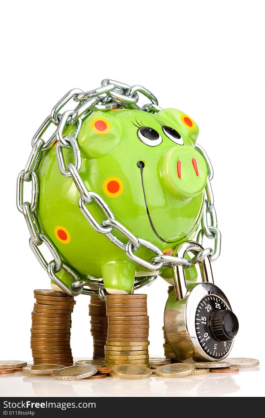 A view of a green piggy bank, wrapped and locked in a metal chain and standing on a pile of coins. Themes: financial security, savings, thrift. A view of a green piggy bank, wrapped and locked in a metal chain and standing on a pile of coins. Themes: financial security, savings, thrift