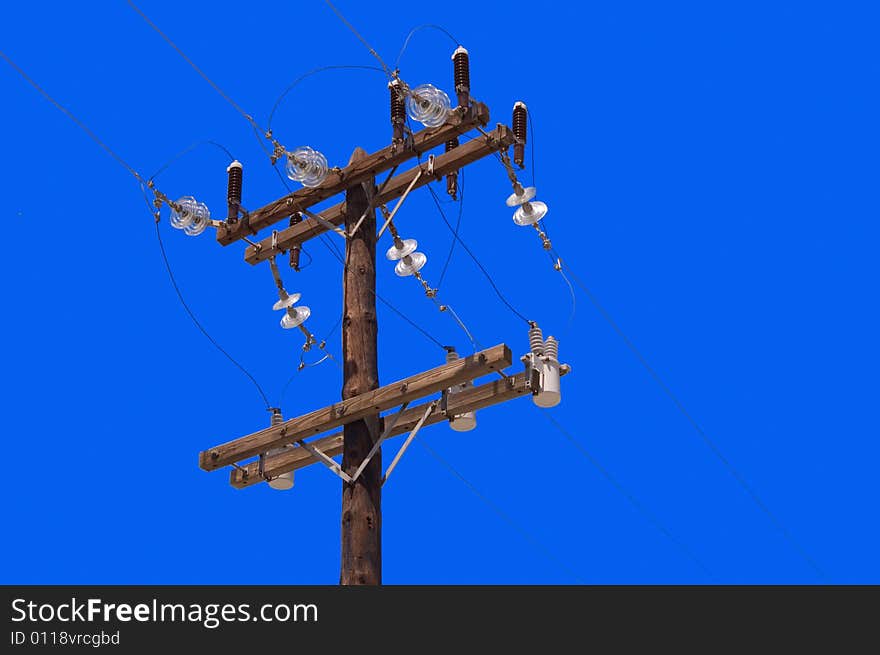 Wooden pillar with electric wires over blue sky