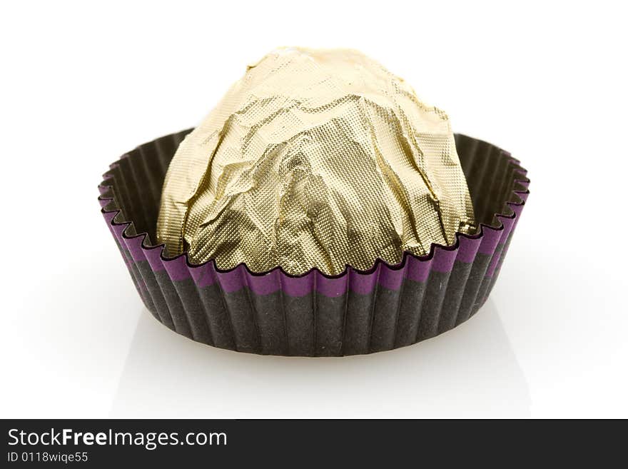 Sweet choco candy wrapped in golden foil, white background. Sweet choco candy wrapped in golden foil, white background