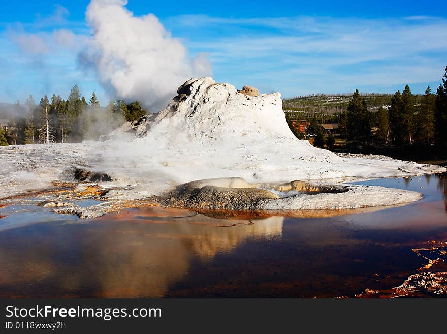 Castle Geyser (of the Upper Geyser Basin) reflecting in a pool - Yellowstone National Park.