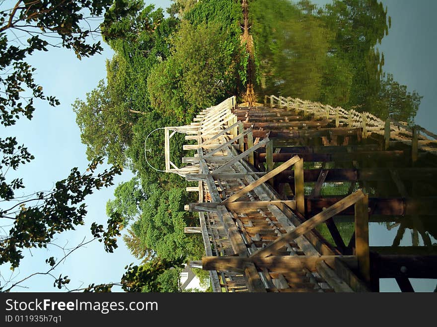 Wooden bridge over river in sunlight