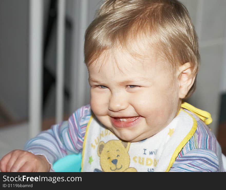 Happy baby laughing with two front teeth showing and eyes full of expression