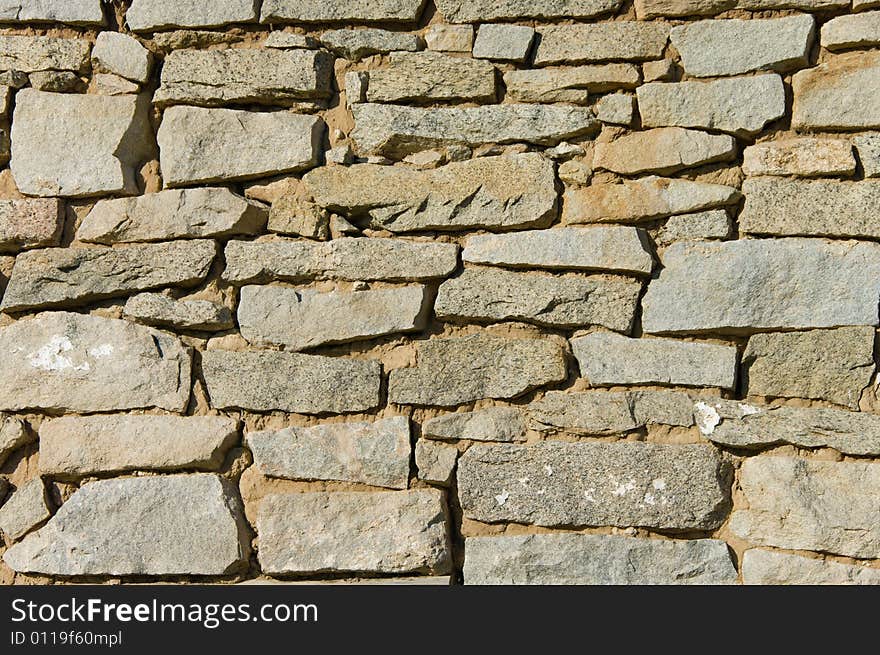 Old stone wall background shot in direct sunlight