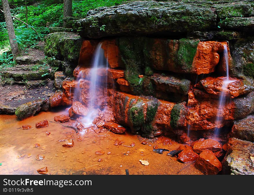 This is a shot of a small waterfall. There is a lot of green, rock steps and ever so small a cliff in this image. The spring is called Yellow Spring. This is a shot of a small waterfall. There is a lot of green, rock steps and ever so small a cliff in this image. The spring is called Yellow Spring.