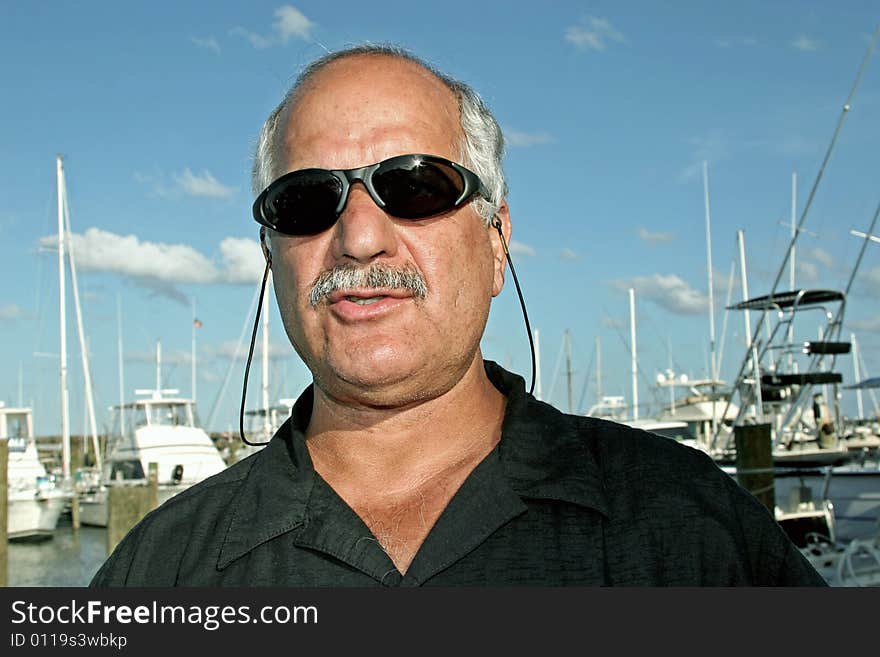 Senior with sunglasses getting ready to go deep sea fishing.