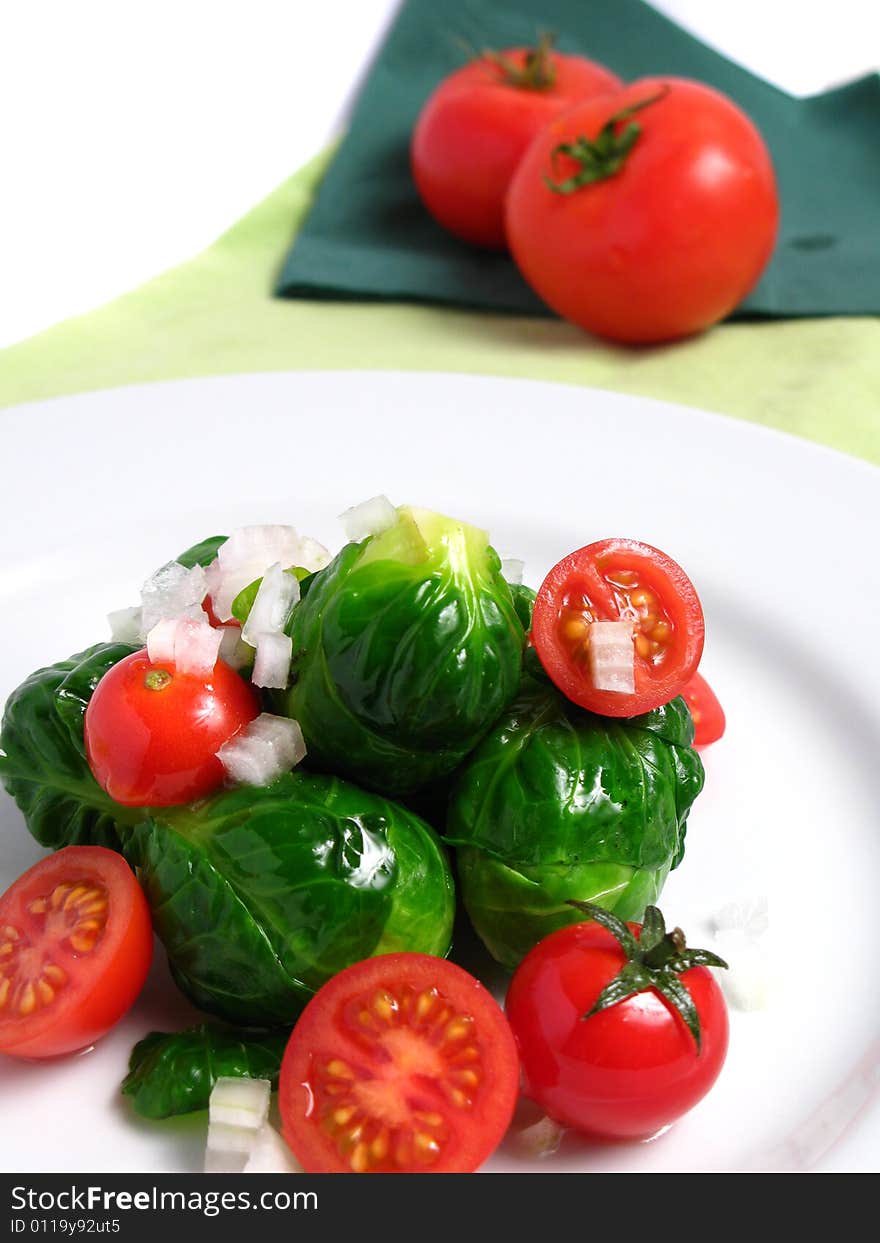 Fresh organic salad of Brussel sprouts and cherry tomatoes, on white background