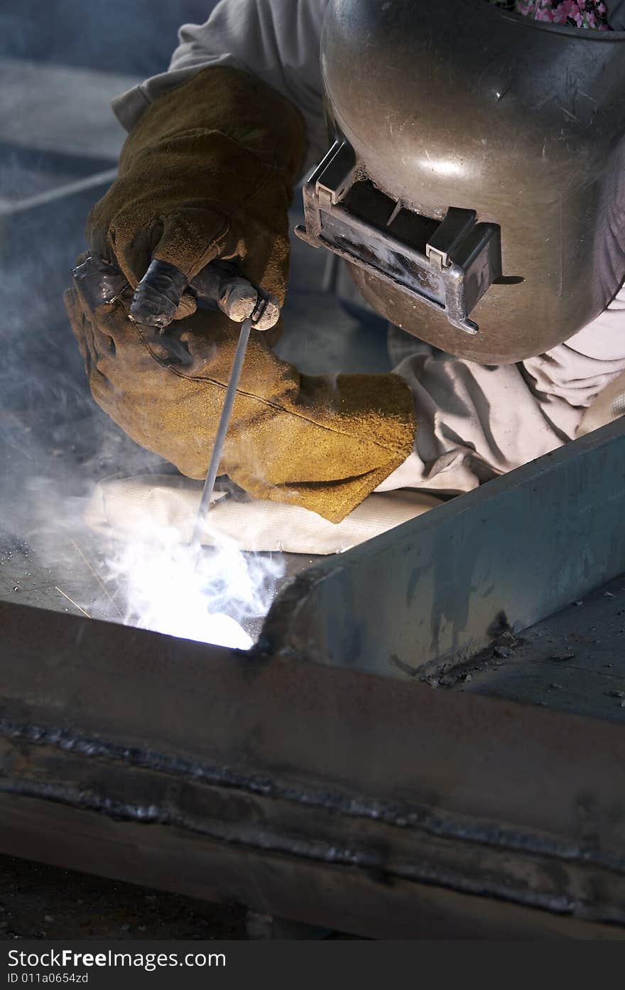 A welder working at shipyard during day shift. A welder working at shipyard during day shift