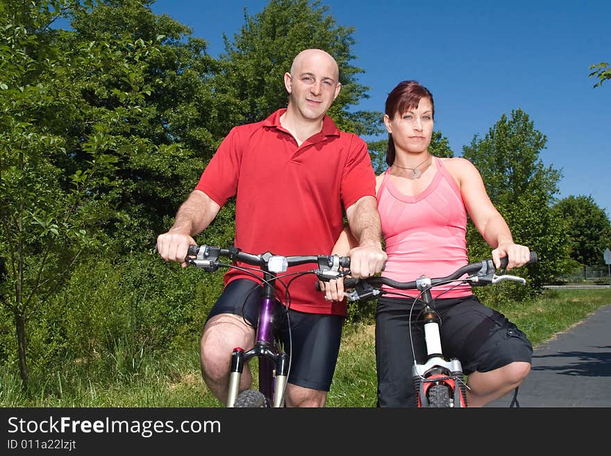 A couple riding through a park. - horizontally framed. A couple riding through a park. - horizontally framed