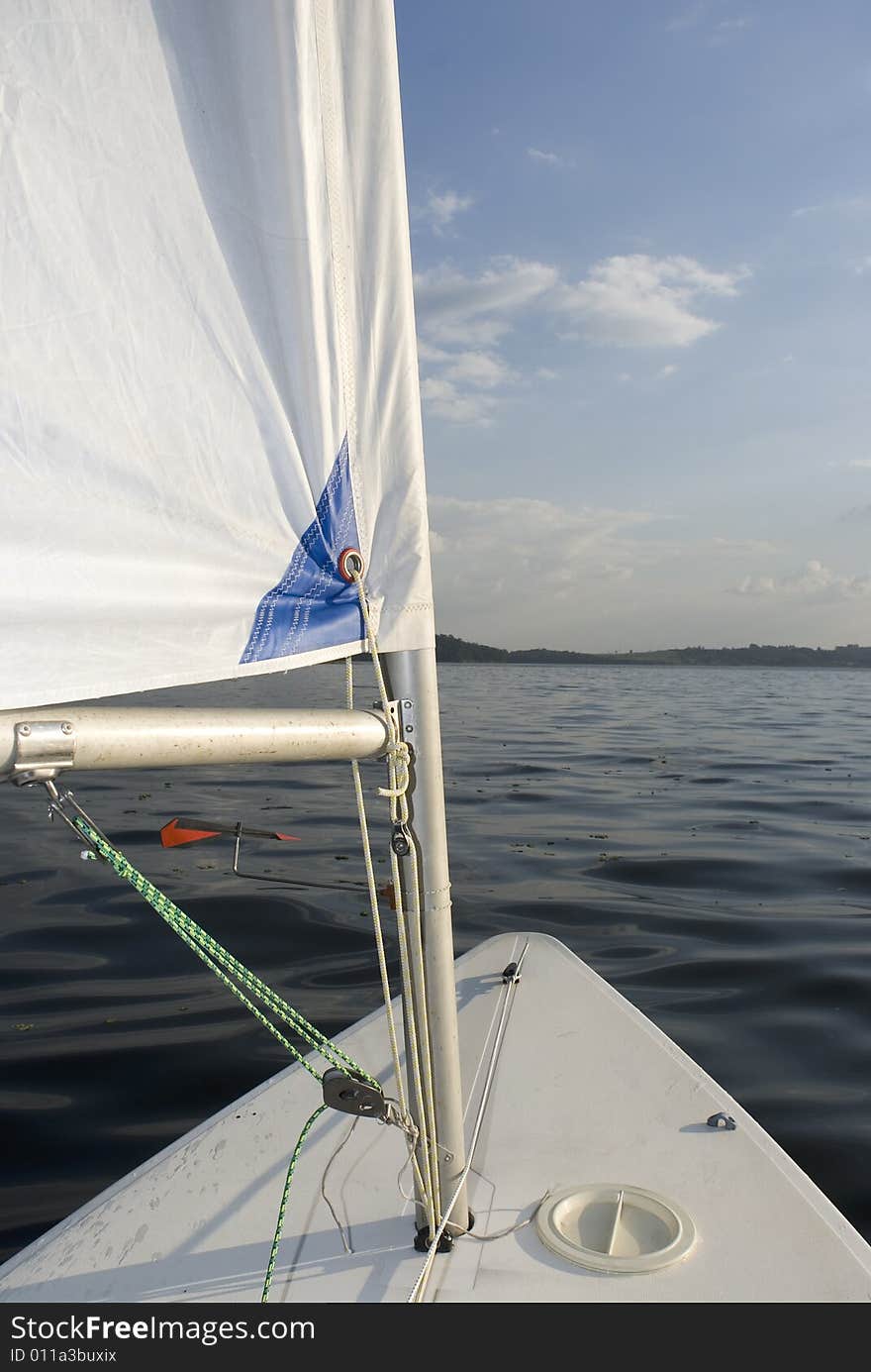 View of a lake from the bow of the sailboat.  Vertically framed shot. View of a lake from the bow of the sailboat.  Vertically framed shot.