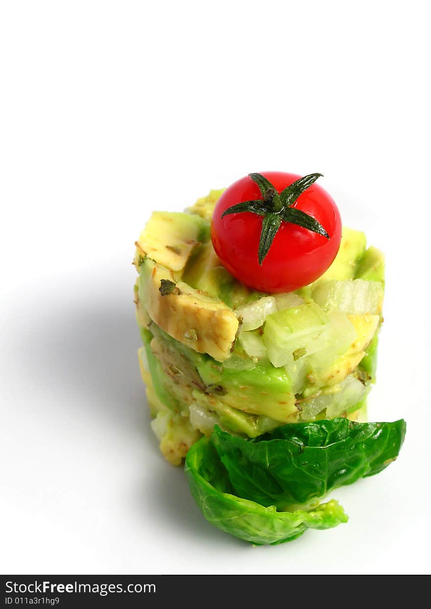 Guacamole tower with cherry tomato on white background