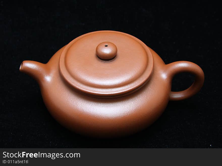 An teapot on black background.