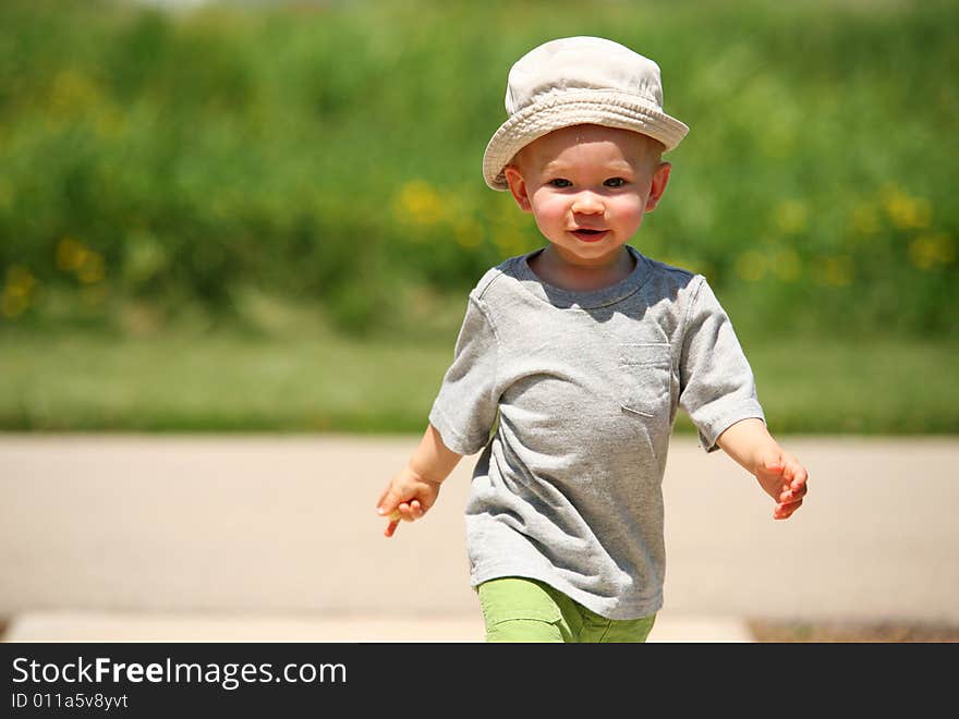 Little sixteen month old boy playing strolling down the walkway. Little sixteen month old boy playing strolling down the walkway.