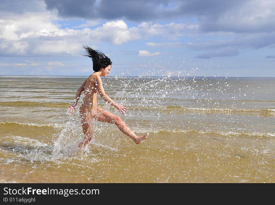 Naked girl running on the beach