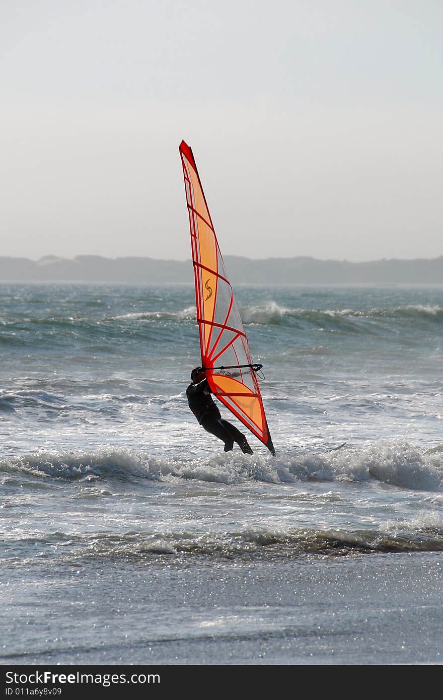 A windsurfer battling the wind and waves in nothern california. A windsurfer battling the wind and waves in nothern california