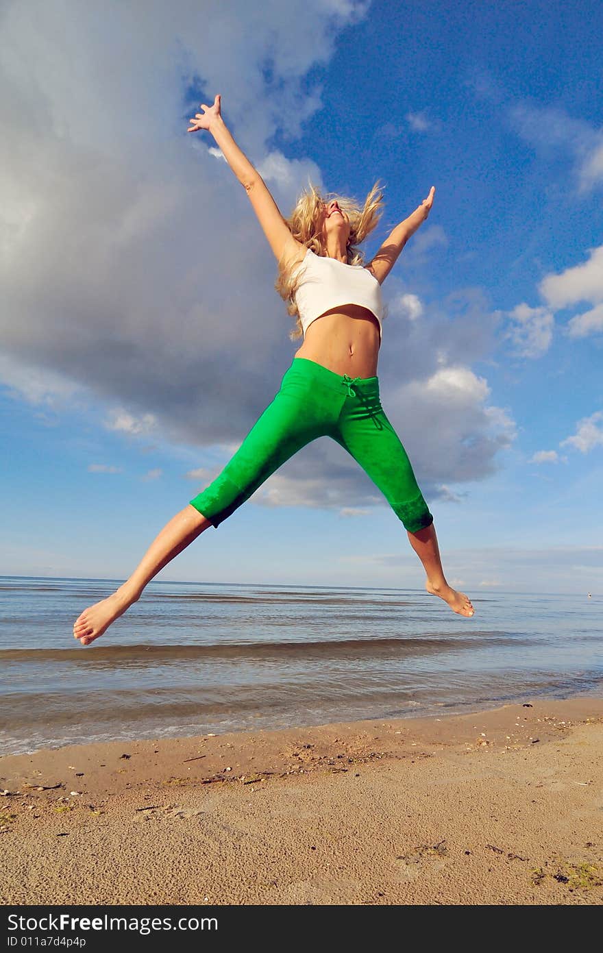 Jumping girl on a backgground of a blue sky