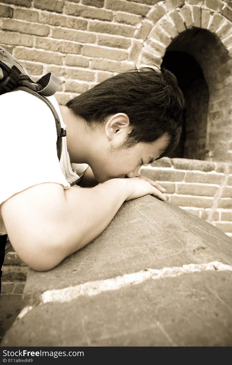 Young male tourist is kissing the great wall in Beijing, China. Young male tourist is kissing the great wall in Beijing, China