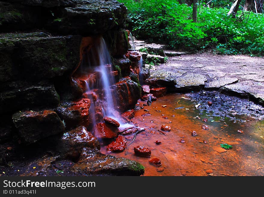 This is a shot of a small waterfall. There is a lot of green, rock steps and ever so small a cliff in this image. The spring is called Yellow Spring. This is a shot of a small waterfall. There is a lot of green, rock steps and ever so small a cliff in this image. The spring is called Yellow Spring.