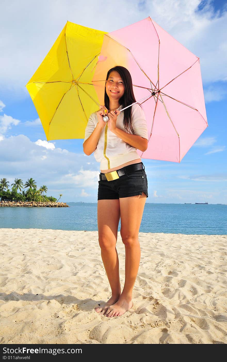 Smiling girl on the beach with two umbrellas. Smiling girl on the beach with two umbrellas.