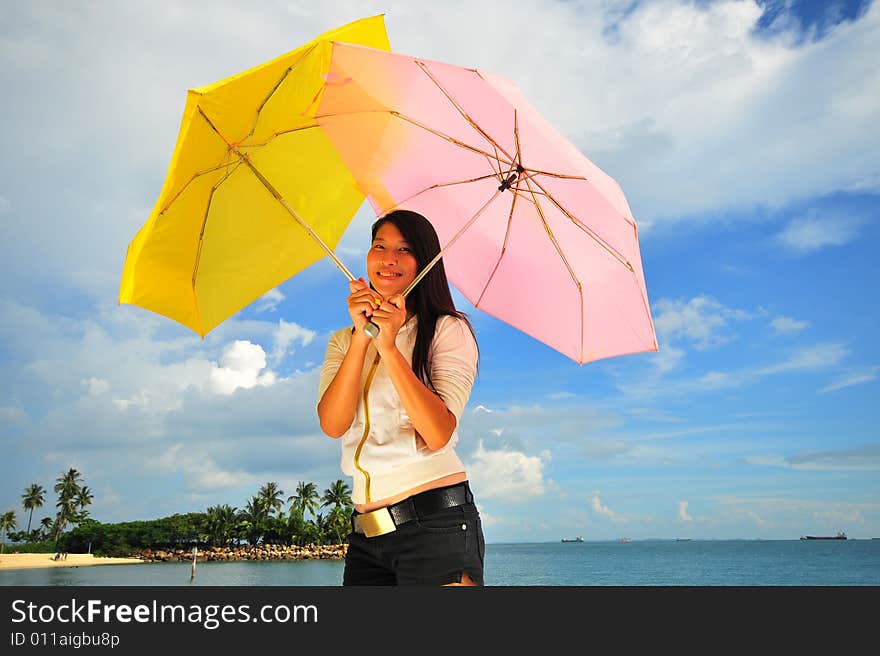 Smiling girl on the beach with two umbrellas. Smiling girl on the beach with two umbrellas.