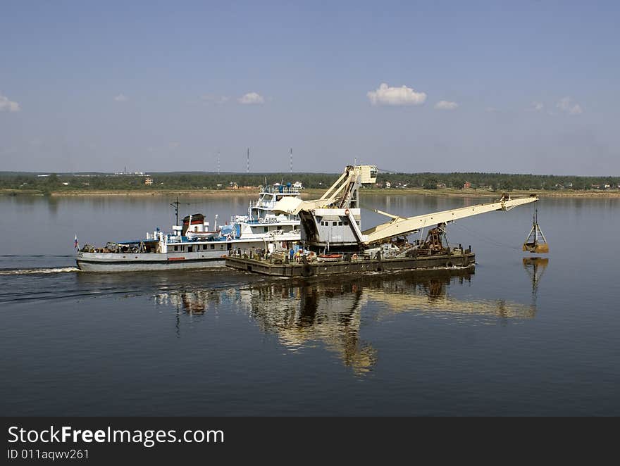 Boot and river`s excavator on the water