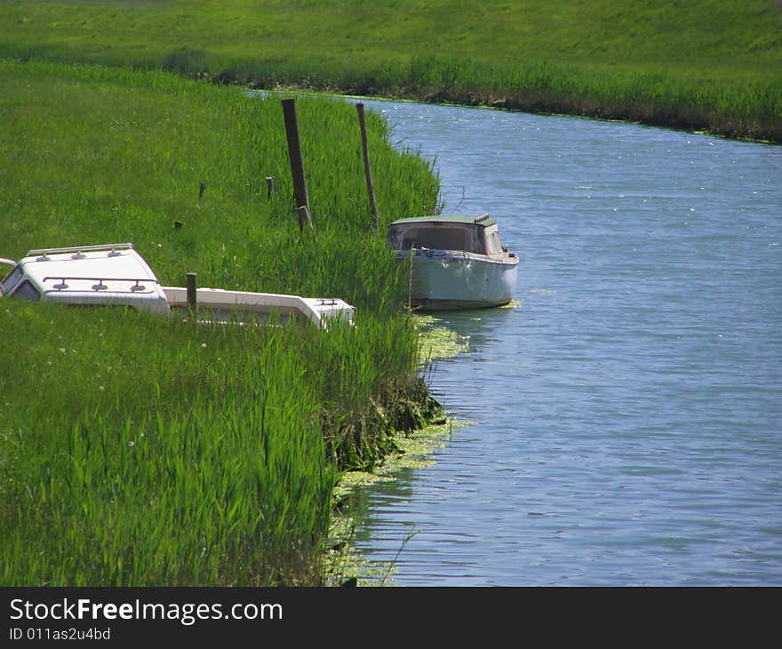 Boat on the blue river just before the riverbend, one tilted boat in the tall green grass

*RAW format available
. Boat on the blue river just before the riverbend, one tilted boat in the tall green grass

*RAW format available