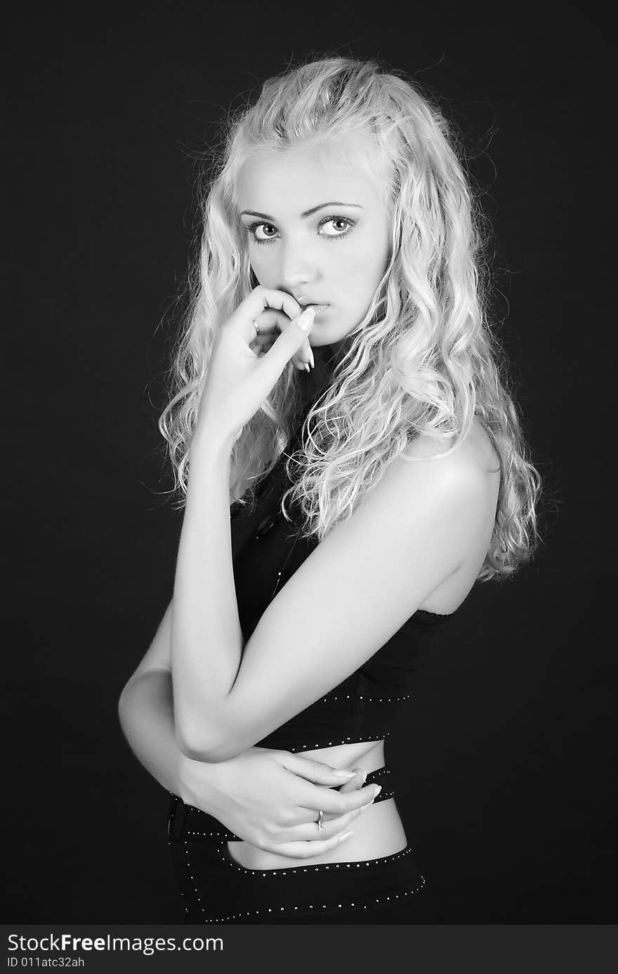 Portrait of young girl in a black suit on a dark background. Portrait of young girl in a black suit on a dark background