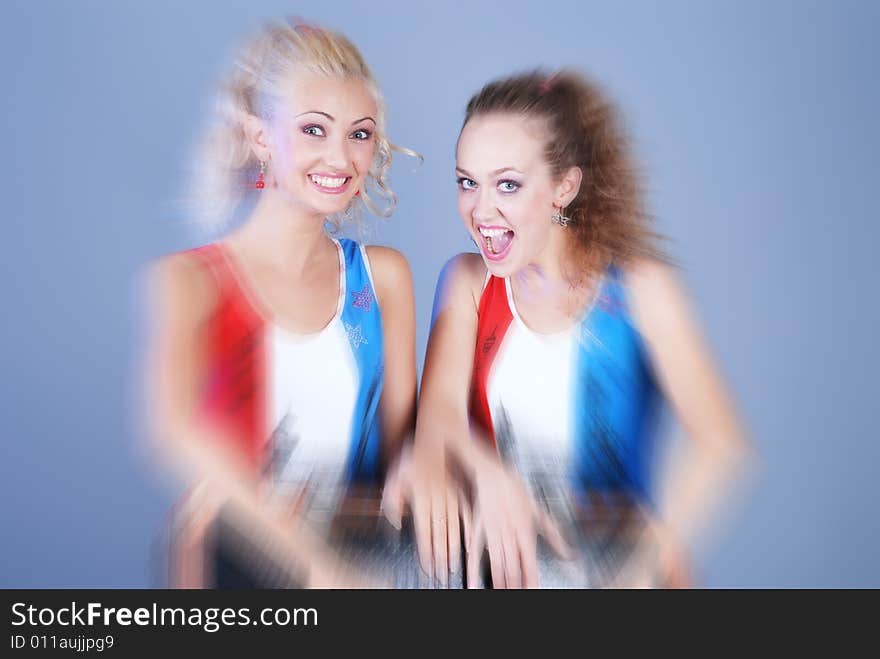 A portrait of two girls is in the identical shirts that are holdings a suitcase, with the washed out edges of shot. A portrait of two girls is in the identical shirts that are holdings a suitcase, with the washed out edges of shot