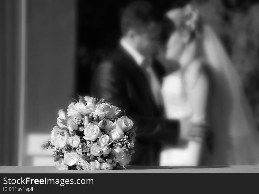 Bunch of white roses and newly-weds on a blackly white background. Bunch of white roses and newly-weds on a blackly white background