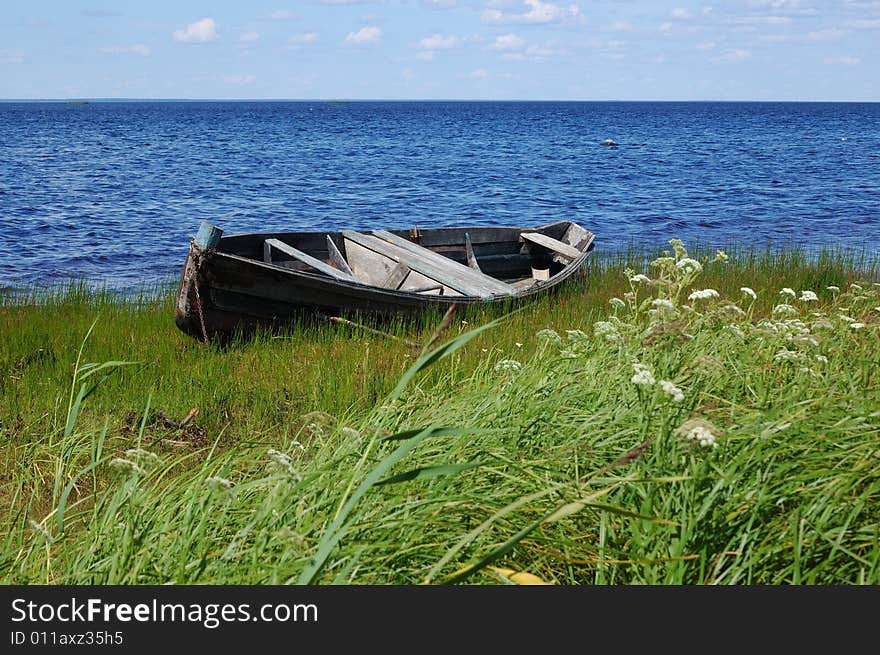 Old fishing wooden black boat on the lake bank, north Russia. Old fishing wooden black boat on the lake bank, north Russia