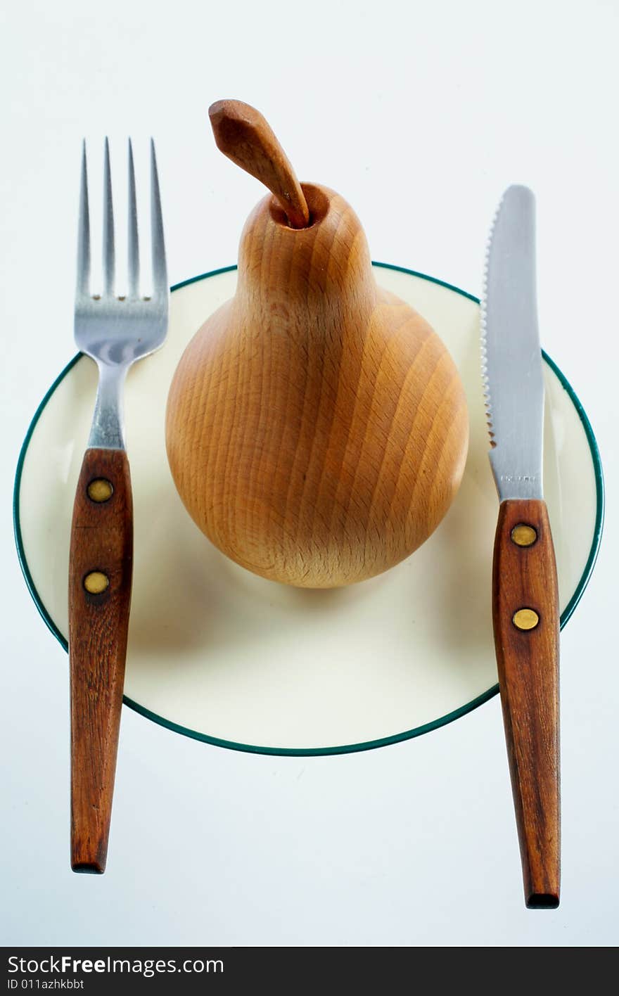 A wooden pear on a plate