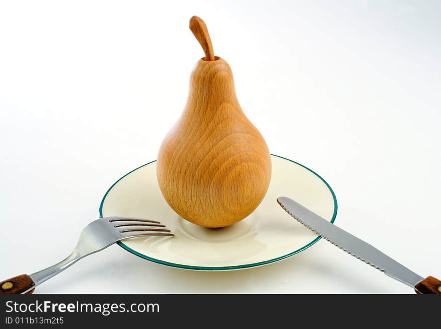 A wooden pear on a plate