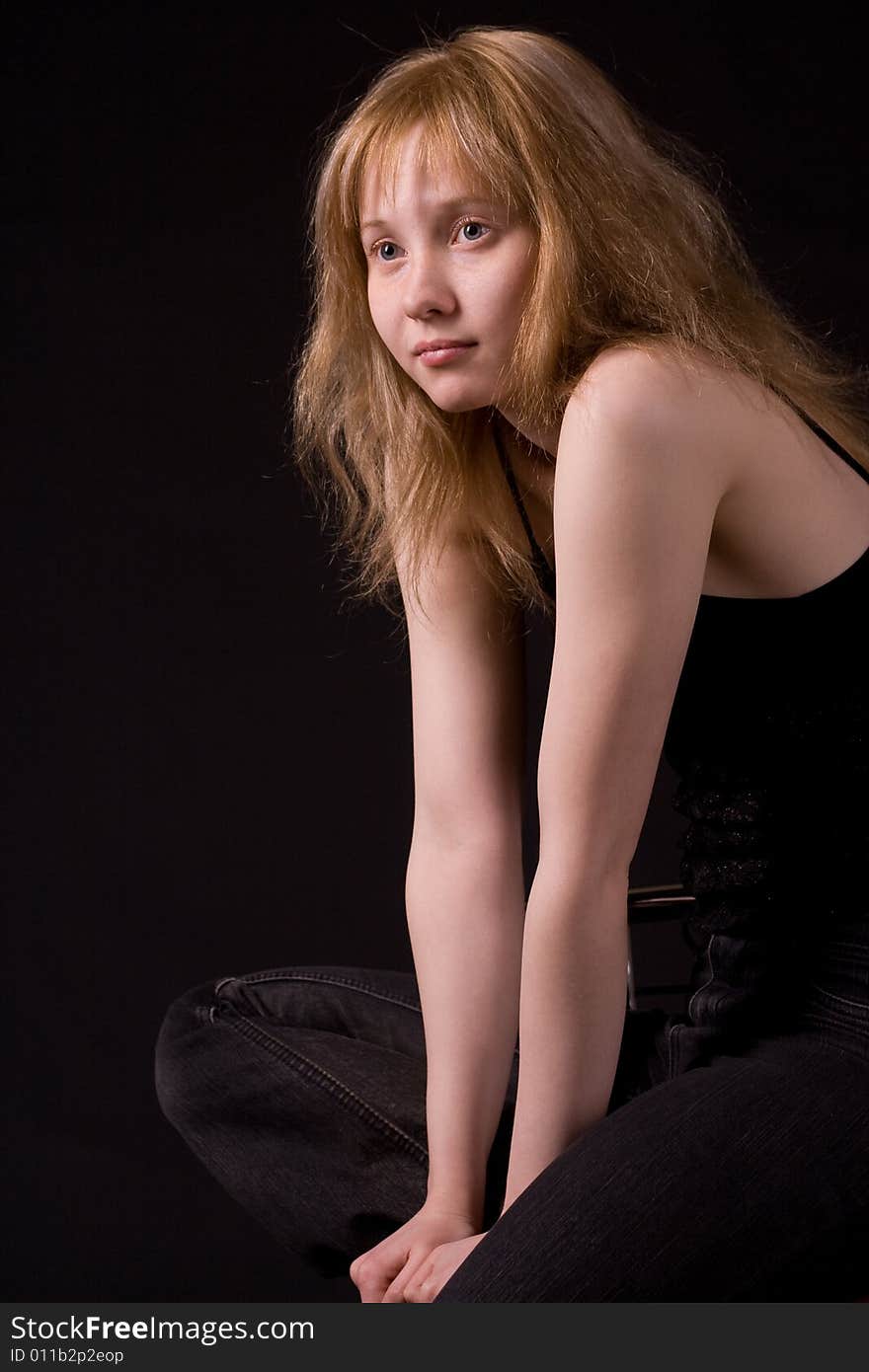 Sitting blonde girl on black