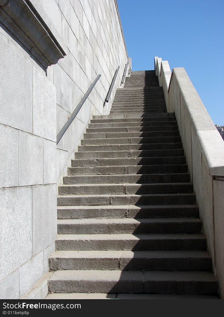 High stone ladder in city on a background of the blue pure sky