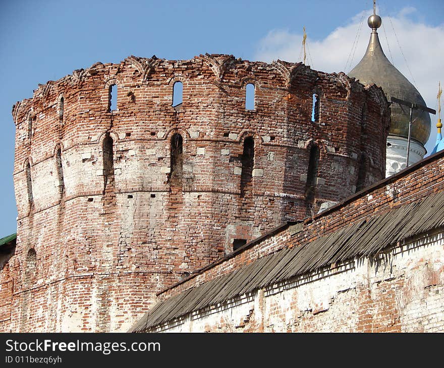 Fortress from a red brick on a background of the blue sky