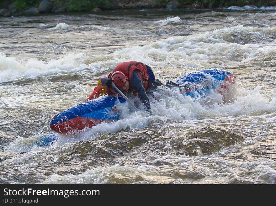 Sportsmen on the blue catamaran in the rapid