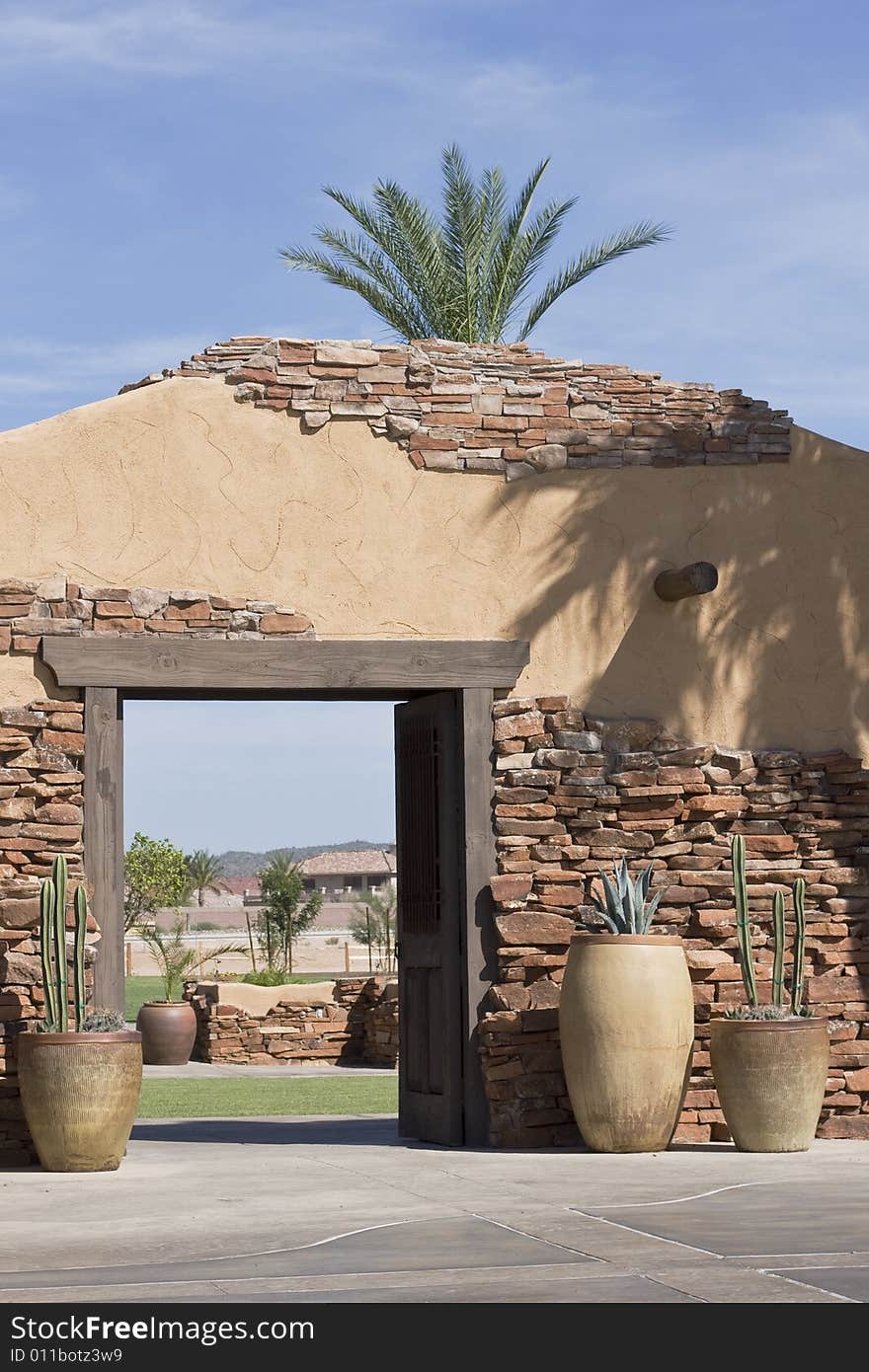 Beautiful old stone entrance with potted cactus vegetation. Beautiful old stone entrance with potted cactus vegetation