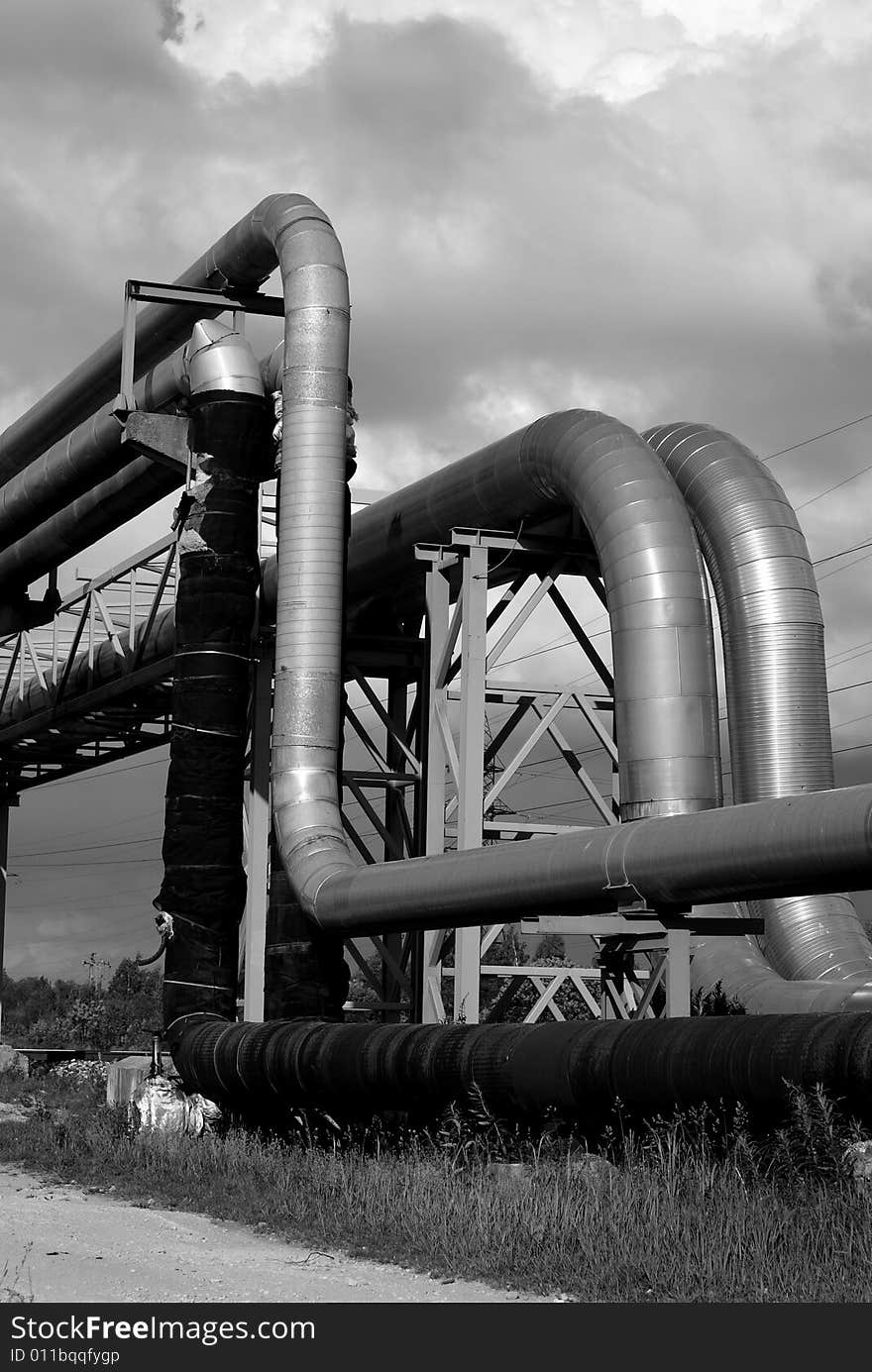 Industrial pipelines on pipe-bridge against sky black and white. Industrial pipelines on pipe-bridge against sky black and white