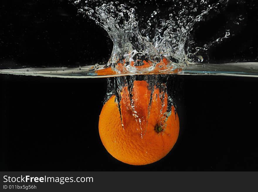 Splashing Orange Into A Water