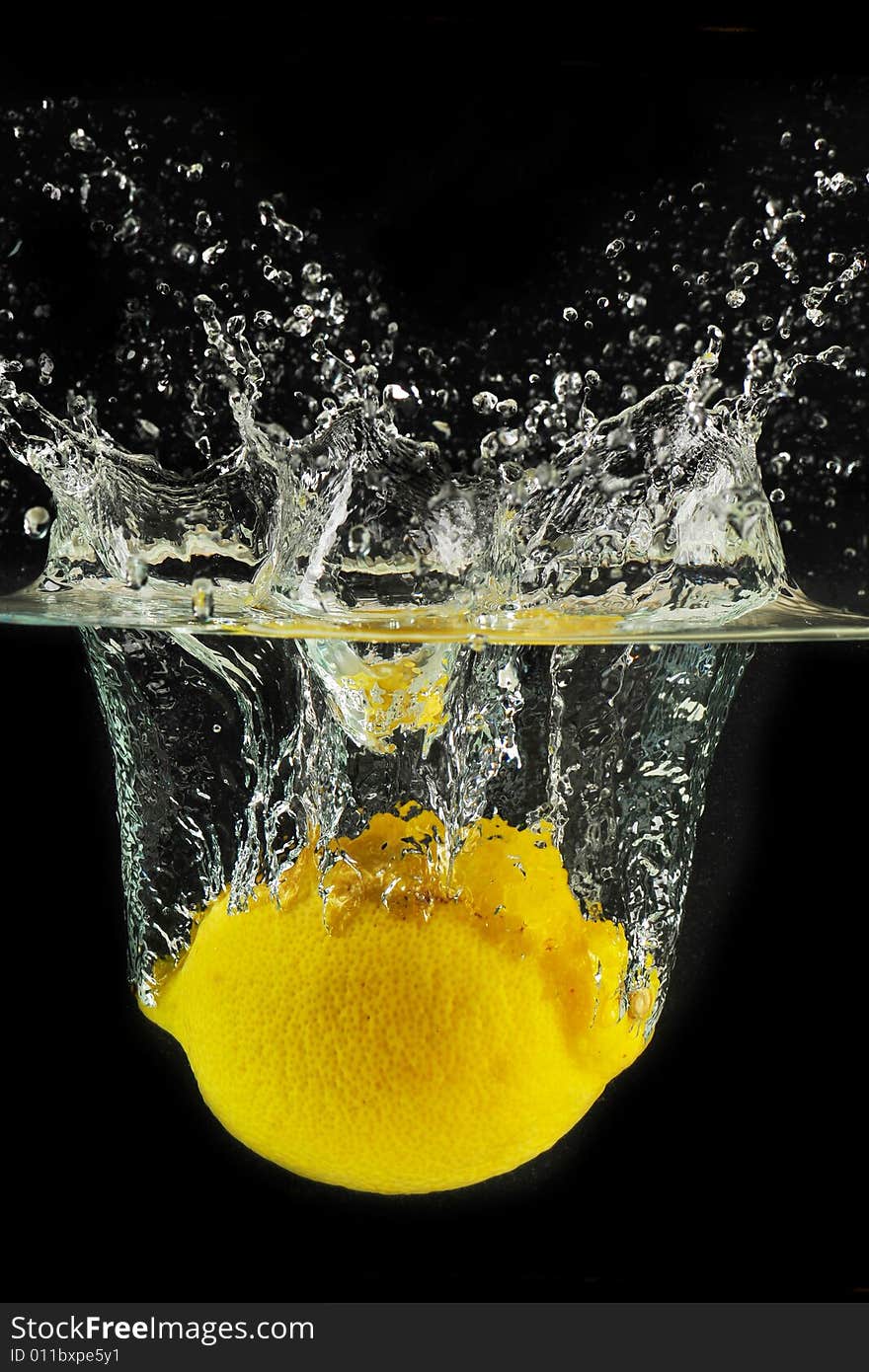 Splashing lemon into a water in black