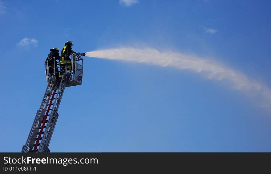 Two fire Fighters standing on a ladder