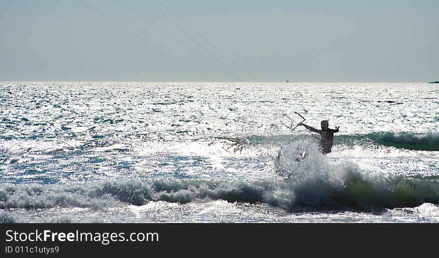 Kitesurfer jumping a wave in summer by a windy day. Kitesurfer jumping a wave in summer by a windy day