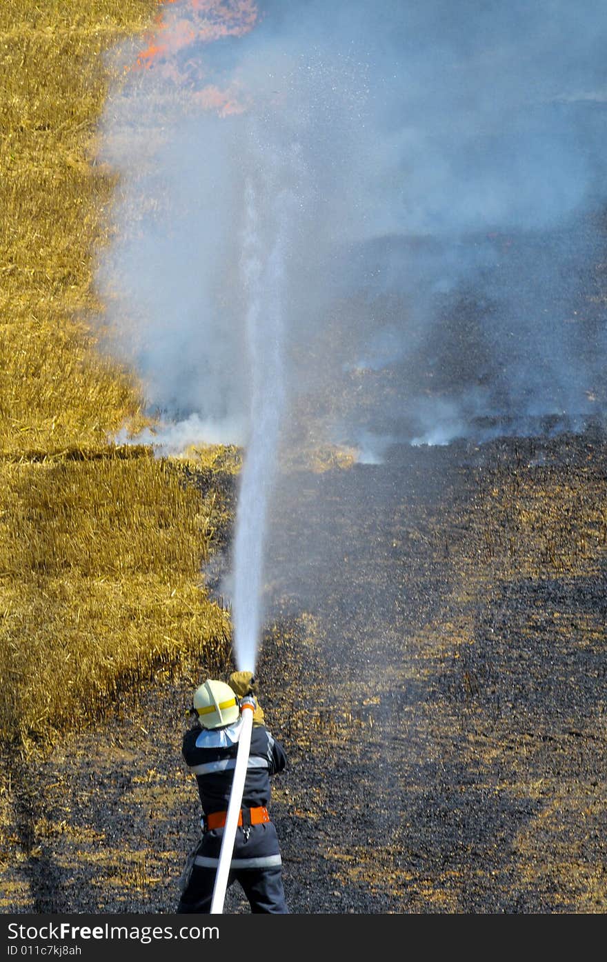 A firefighter extinguish the burning stubble field